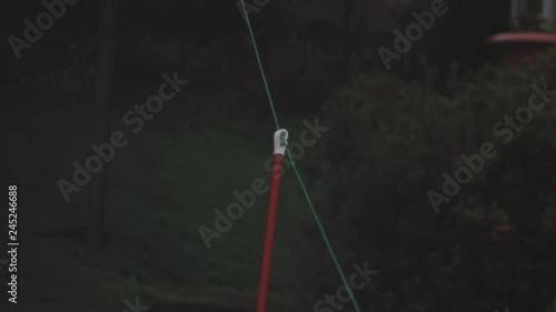 Orange washing line pole blowing in the stormy wind with a green garden in the background