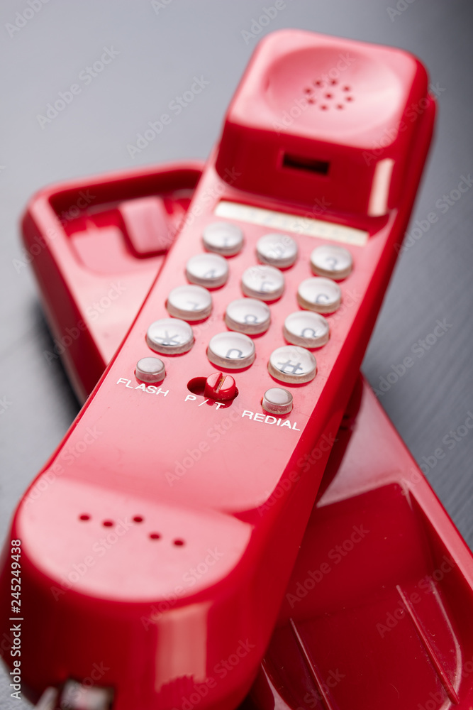 Old analog telephone. Red phone on a wooden dark table. Old analog telephone. Red phone on a wooden dark table.