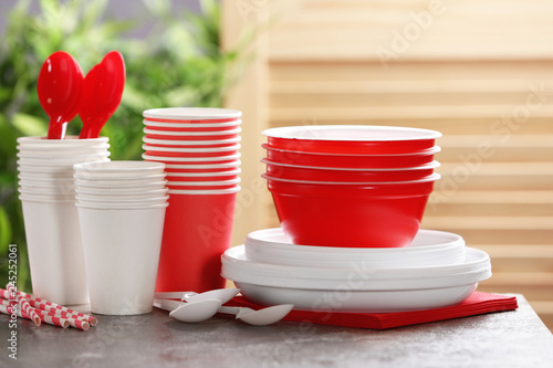 New plastic dishware on table against blurred background. Table setting