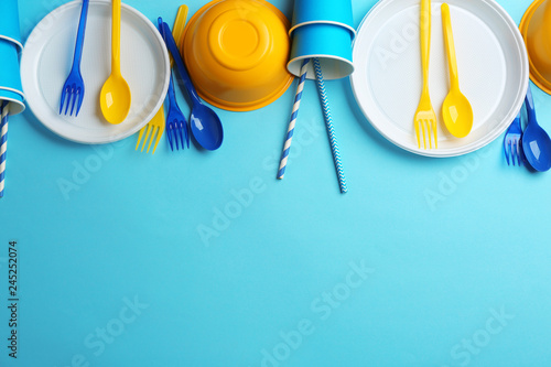 New plastic dishware and space for text on color background. Table setting