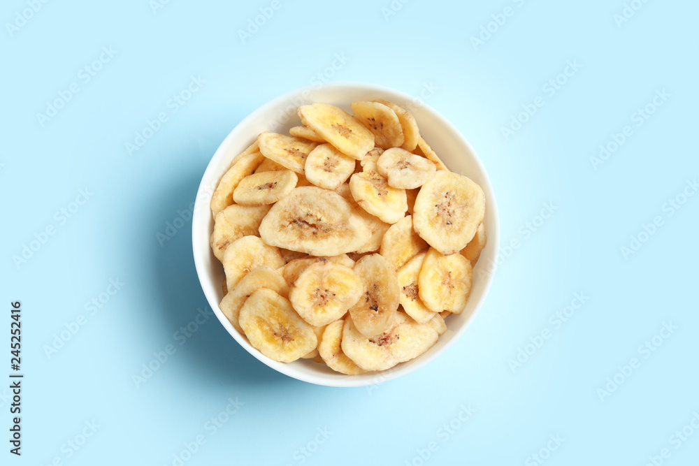 Bowl with banana slices on color background, top view. Dried fruit as healthy snack Bowl with banana slices on color background, top view. Dried fruit as healthy snack