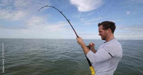 Shark fishing - man sport fishing on boat in Florida. Travel tourist man catch and release of spinner shark. From Florida keys.