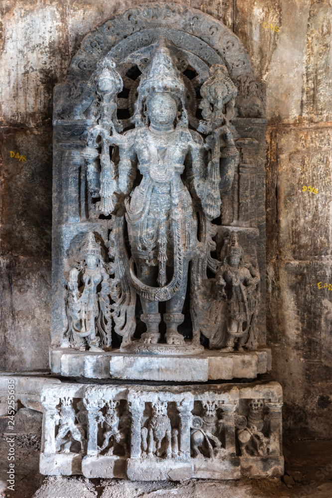 Belavadi, Karnataka, India - November 2, 2013: Veera Narayana Temple. Closeup of blue-black stone Vishnu statue inside Entrance hall to the sanctuary grounds. Damage.