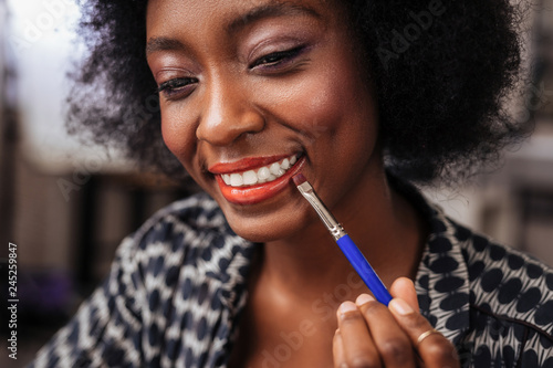 Amazing african american woman with curly hair smiling happily