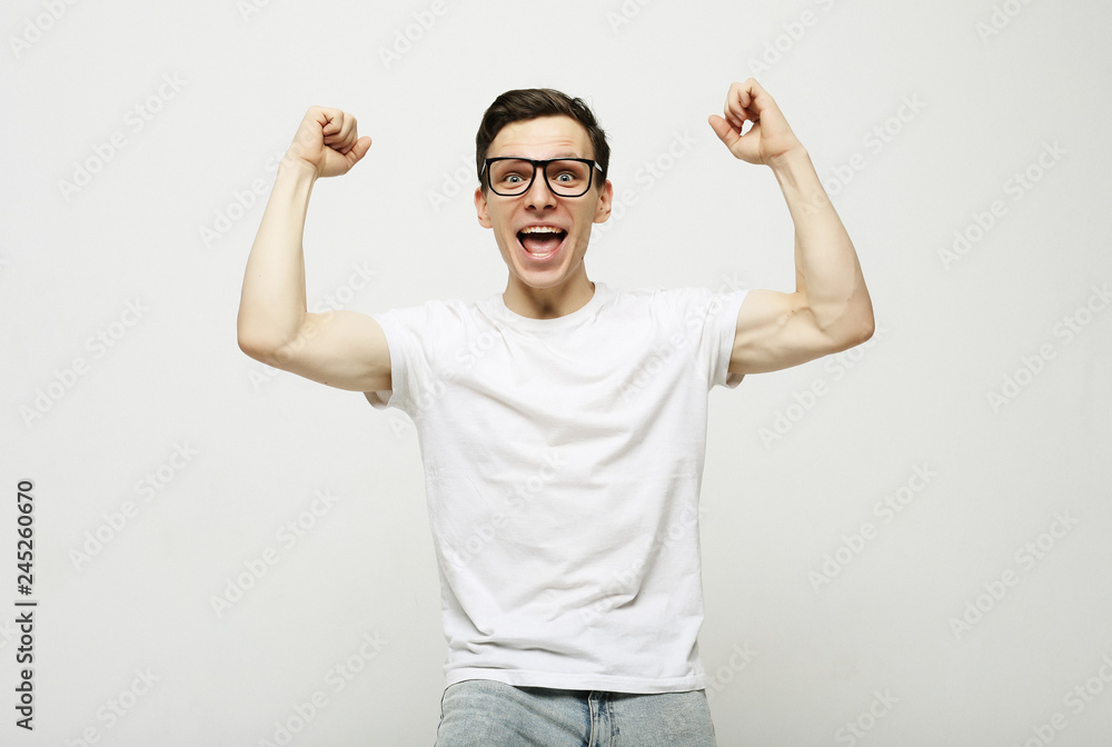 Happy young handsome man gesturing and keeping mouth open Happy young handsome man gesturing and keeping mouth open