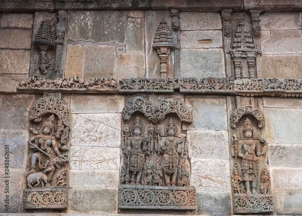 Belur, Karnataka, India - November 2, 2013: Chennakeshava Temple. Large Brown wall stone side panel sculpture of Lord Vishnu surrouned by his wives.