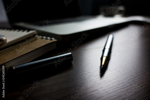 Close up office desk table with laptop, note book, mobile coffee and pen. Selective focus. Business concept. Copy space.