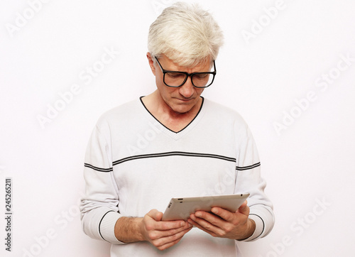 lifestyle, tehnology and people concept: Happy senior man using digital tablet.