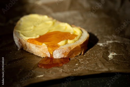honey on buttered slice of bread on parchment