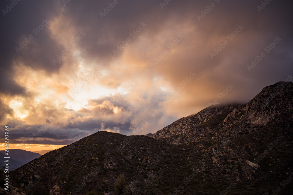 Soft glowing clouds over mountain ridges at sunset
