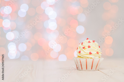Cupcake with little hearts and fairy lights. Empty space for text