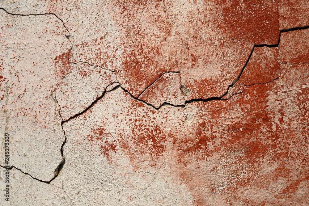 Obraz premium Concrete wall texture with cracked plaster. Weathered uneven rough surface. Red background. Perfect for grunge design.
