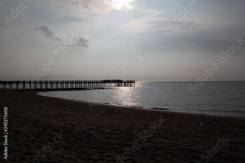 Sunset on the sea with a pier in the background