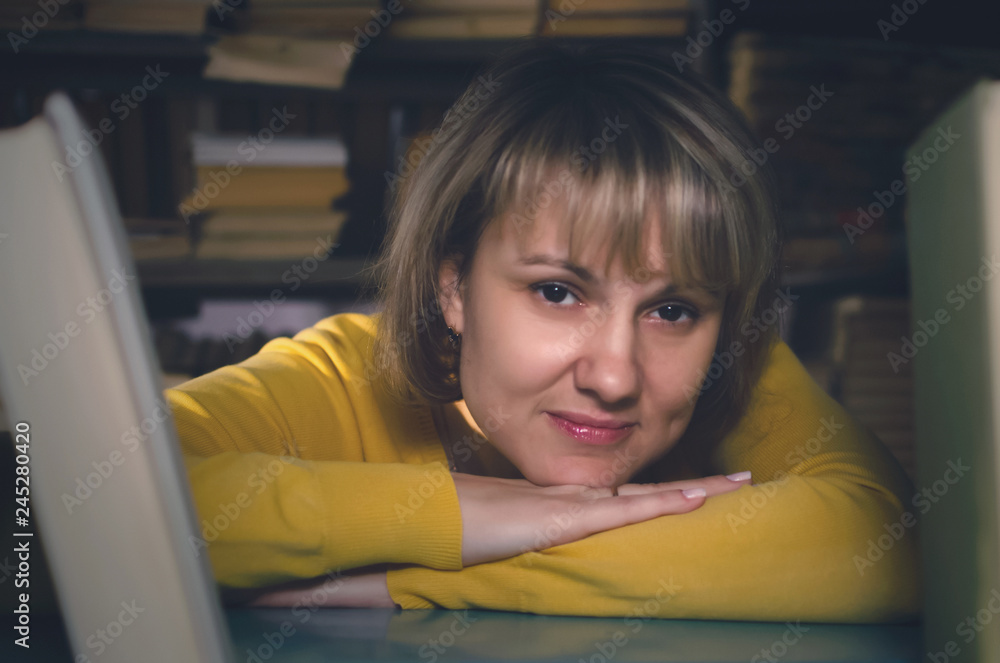 Woman a librarian is looking through a bookshelf in a library. Woman a librarian is looking through a bookshelf in a library.