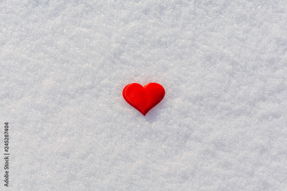 Red heart on glittering snow. Vilentine's day theme. Copy space