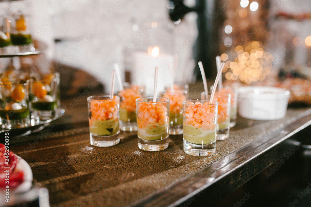 appetizer with shrimp and avocado in a glass, buffet table