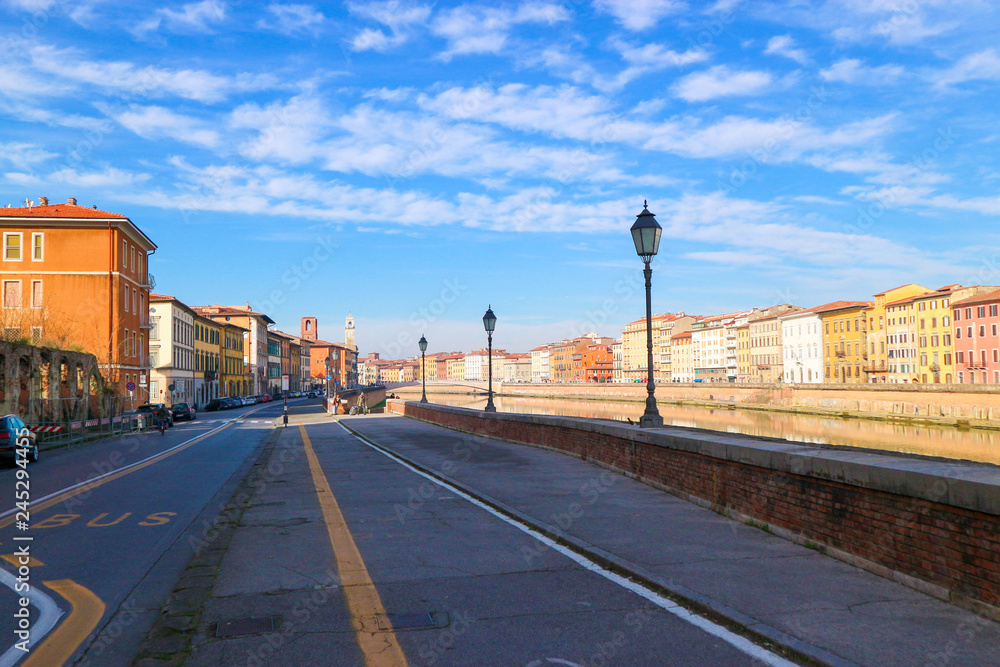 Arno river embankment in Pisa at winter sunny day, Tuscany, Italy