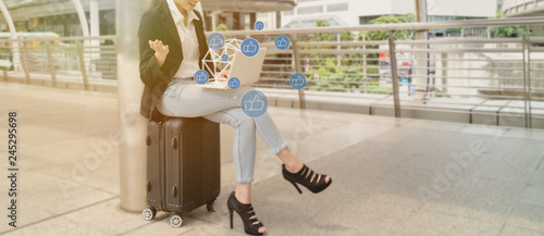 woman sitdown on the luggage and check the social network media and use application in online community for sharing and commenting while travel around the world photo