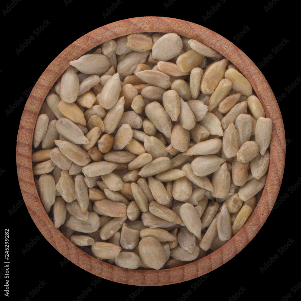 shelled seeds of sunflower in wooden cup isolated on black background. top view shelled seeds of sunflower in wooden cup isolated on black background. top view
