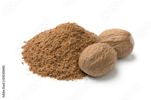 Heap of ground nutmeg and whole nutmeg seeds photo