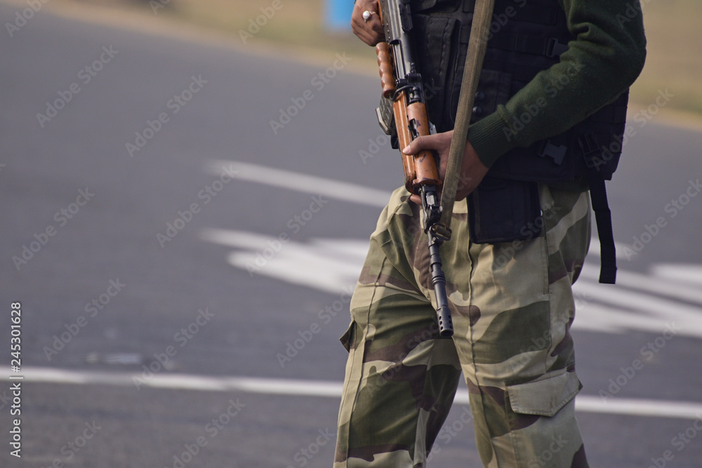 Security guard with rifle standing on outside to protect the area. Security guard with rifle standing on outside to protect the area.