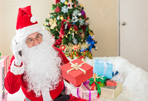 Senior Santa Claus showing many colorful small gift boxes .Kind and Happiness Santa Claus has a gift box for children .Christmas, holidays, new year, currency and shopping concept © kittipong