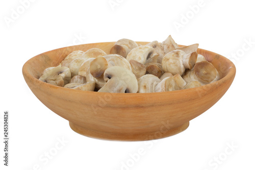 heap of champignons in wooden plate isolated on white background