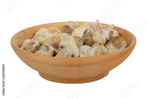 heap of champignons in wooden plate isolated on white background