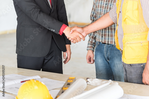 Closed up of businessman shake hands with engineering in construction renovate building site.