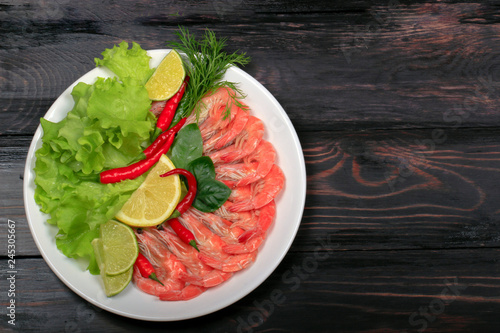 cooked shrimps in plate on wooden background. top view photo