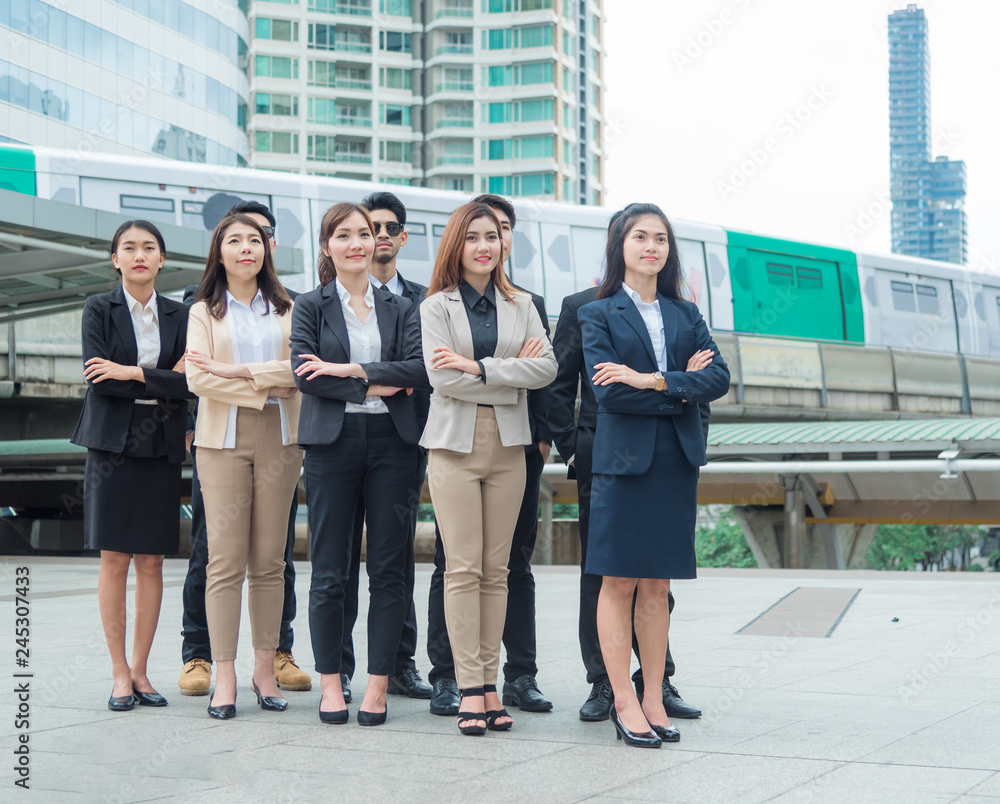 Fototapeta premium Group of professional multiracial business people standing in row outdoor office, background is modern building in modern city