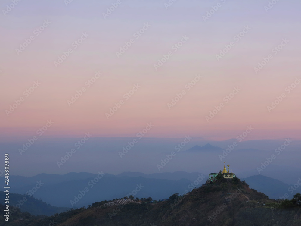 Landscape view in colorful morning sky with golden pagoda on hill in Myanmar.