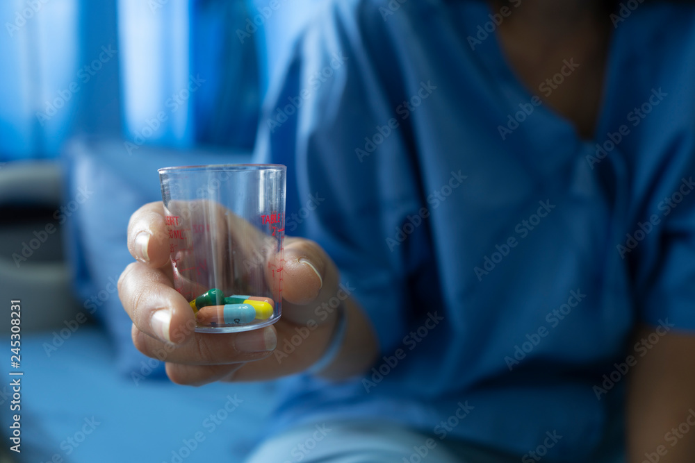 Blue dress woman on hospital bed Have medicine on hand Blue dress woman on hospital bed Have medicine on hand