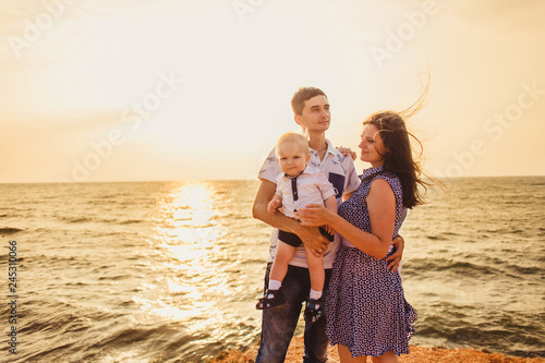 Mom, dad and son. The family strolls along the stony beach by the sea. © artem_goncharov