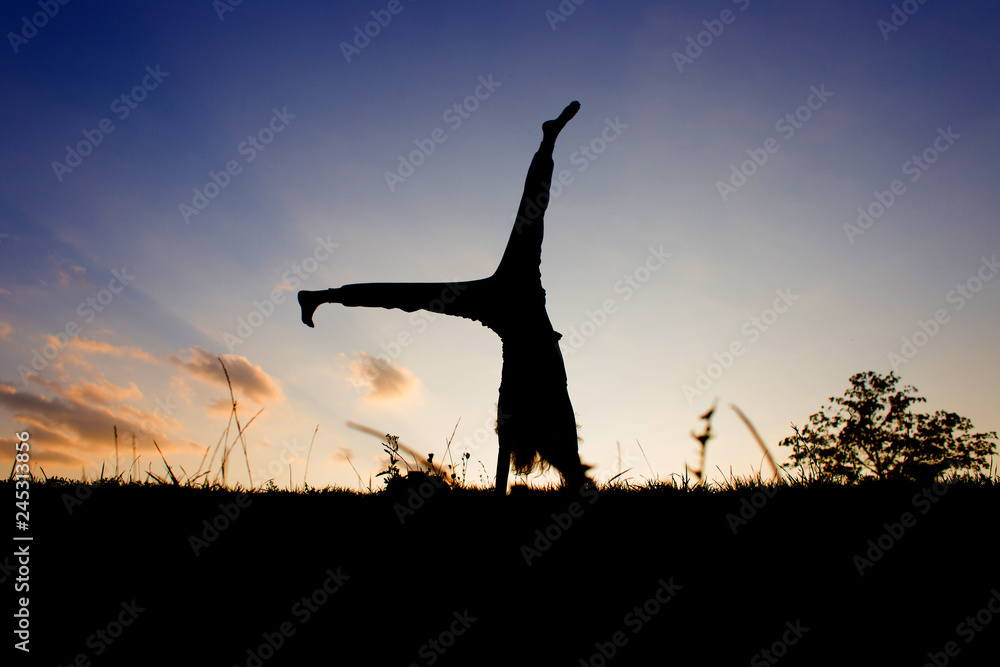 Silhouette of a yogi at sunset. Exercises for the balance.