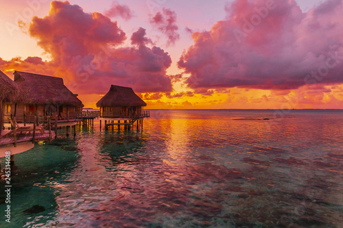 Wybrzeże z tropikalną plażą i turkusową wodą wewnętrznej laguny atolu Tikehau o zachodzie słońca. Archipelag Tuamotus, Polinezja Francuska, Ocean Południowy Pacyfik.