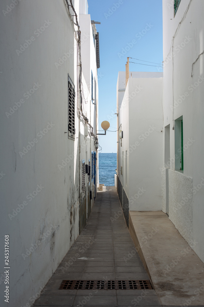 The passage to the ocean between the houses in the city in Arrieta on the island of Lanzarote.