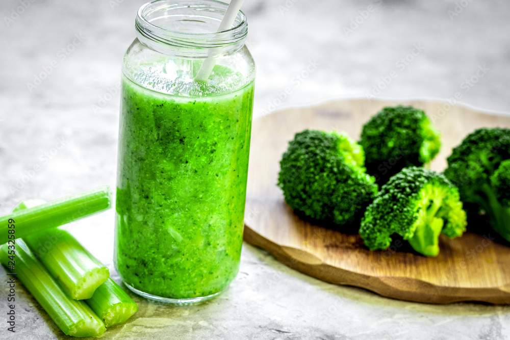 Green vegetable smoothie in glass at gray background Green vegetable smoothie in glass at gray background