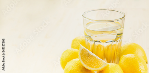 Glass of water with piece of lemon or fresh hand made lemonade
