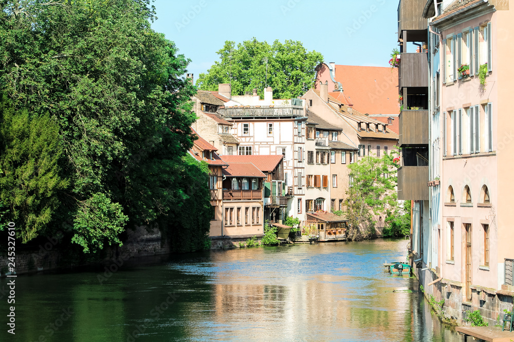 Half-timbered houses at a water canal in the picturesque old town (La Petite Fance) of Strasbourg during a summer day (Strasbourg, France, Europe)