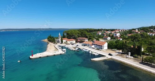 AERIAL - Flight with the DJI Phantom 4 on summer holiday directly at the holiday home over the deep blue Adriatic Sea and part of the village Zdrelac on the island of Pasman in Croatia. photo