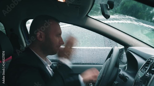 A tired businessman is sitting in the car with his head on the steering wheel, then he slap himself on the cheeks, takes the briefcase and gets out of the car.