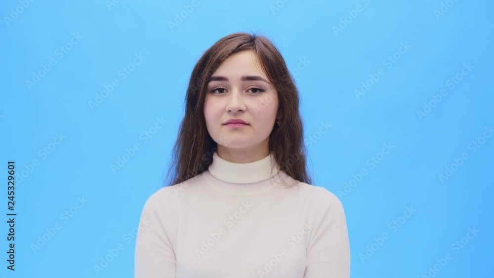Beautiful young woman with clean, perfect skin.Looking straight dičina shows a gesture of silence. Beautiful young woman with clean, perfect skin.Looking straight dičina shows a gesture of silence.
