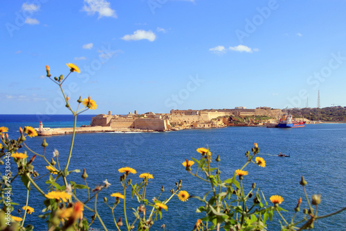 Lighthouse and Fort Ricasoli on a sunny day on the island of Malta.