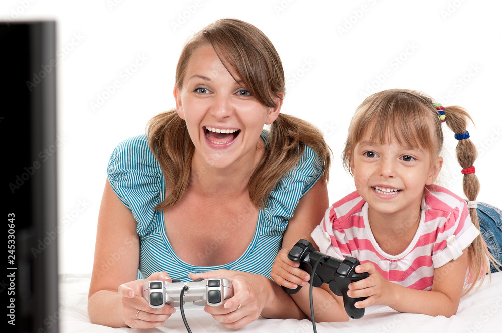 Mom and Daughter holding Joysticks and Playing Video Games on console together. Happy Family - Mother and little Girl having Fun gaming on white background. Woman with Child playing Computer Game. Mom and Daughter holding Joysticks and Playing Video Games on console together. Happy Family - Mother and little Girl having Fun gaming on white background. Woman with Child playing Computer Game.