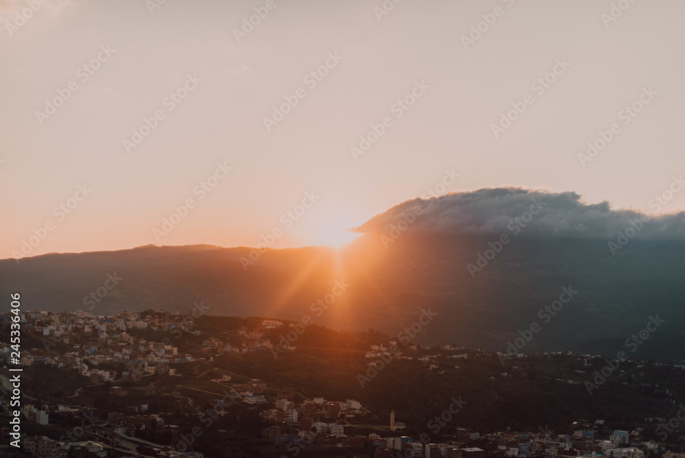 Cityscape on hill and clouds with sun Cityscape on hill and clouds with sun