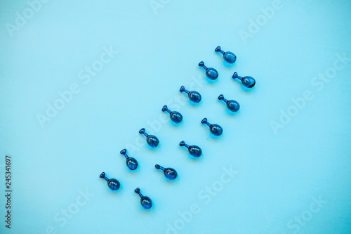 Fillers or capsules with hyaluronic acid on a blue background. Skin care and facial health.