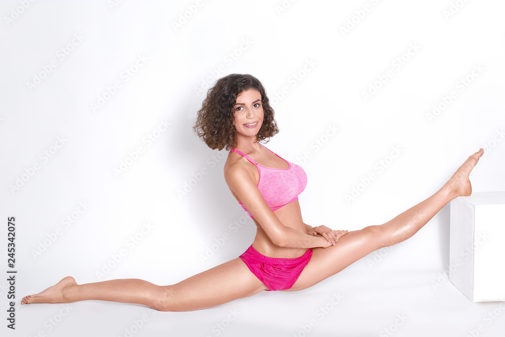 Sexy gymnast girl showing stretching on a white background
