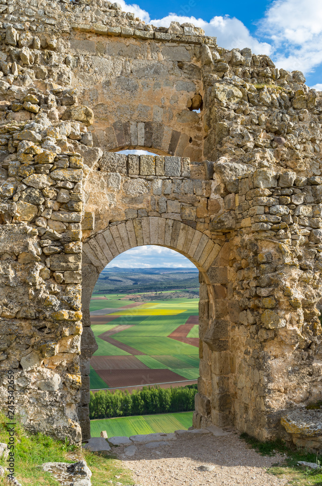 Double arches in the ruins of castle of Gormaz wall with farm fields from 