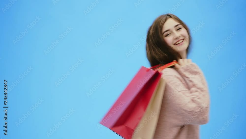 Young pretty girl doing incredibly pleasing shopping. During this time, she puts bags with shopping for her shoulders. Young pretty girl doing incredibly pleasing shopping. During this time, she puts bags with shopping for her shoulders.